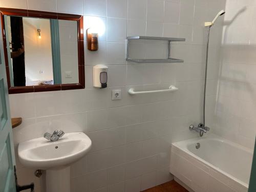a white bathroom with a sink and a tub at Posada la escuela - Bed&Breakfast in Cicera