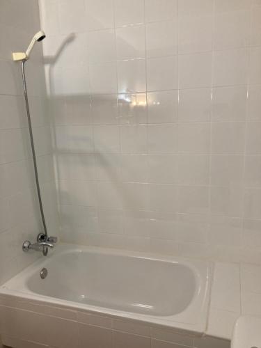 a white bath tub in a white tiled bathroom at Posada la escuela - Bed&Breakfast in Cicera