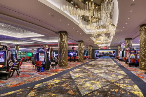a casino with many slot machines and a chandelier at Hyatt Regency JFK Airport at Resorts World New York in Queens