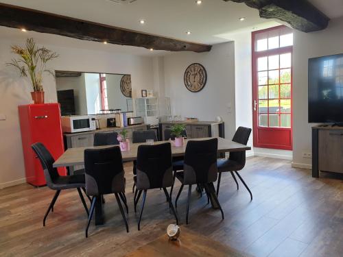a dining room with a table and chairs and a kitchen at Chambres de Villée in Saint-Georges-de-Gréhaigne