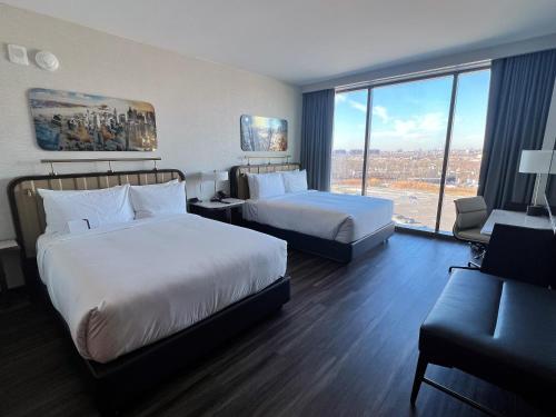 a hotel room with two beds and a large window at Hyatt Regency JFK Airport at Resorts World New York in Queens