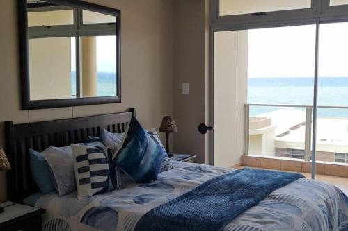 a bedroom with a bed with a view of the ocean at Santorini Unit R in Margate