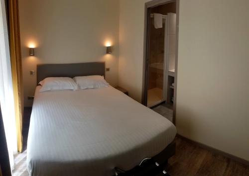 a bedroom with a white bed in a room at Hotel de la Couronne in Aix-les-Bains