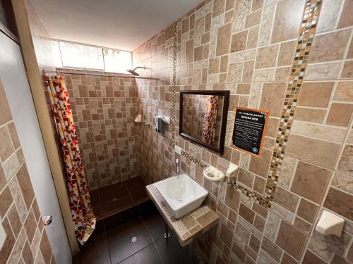 a small bathroom with a sink and a mirror at Chikan Hoteles in Arequipa