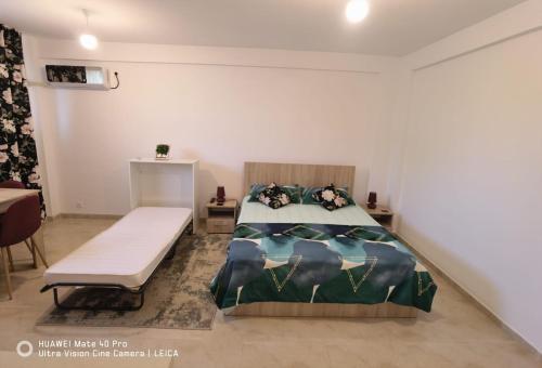 a bedroom with a bed and a bench in it at Studio Lorena in Mangalia