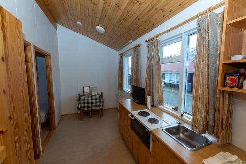 a kitchen with a sink and a window at Kaffi Holar Cottages and Apartments in Sauðárkrókur