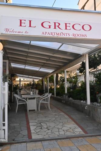 a patio with tables and chairs under a canopy at El Greco Nei Pori in Nei Poroi