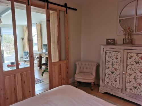 a bedroom with a bed and a dresser and a chair at GÎTE AZKENDANTZA 2a6 PERS AVEC CARAVANE INSOLITE in Ascain