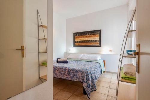 a small bedroom with a bed and a shelf at Pergola 707 in Stintino