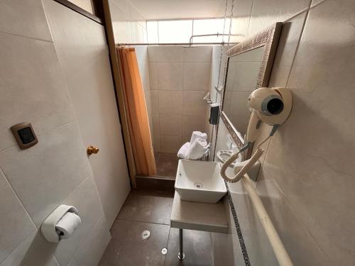 a bathroom with a sink and a mirror and a shower at Chikan Hoteles in Arequipa