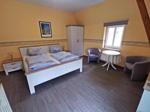 a bedroom with a bed and a table and chairs at Pension Ginko in Wernigerode