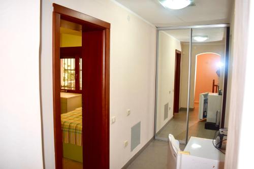 a bathroom with a mirror and a bedroom with a bed at Family Villa in Petrovac na Moru