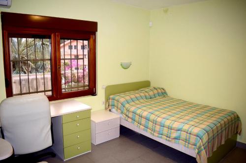 a bedroom with a bed and a desk and a window at Family Villa in Petrovac na Moru