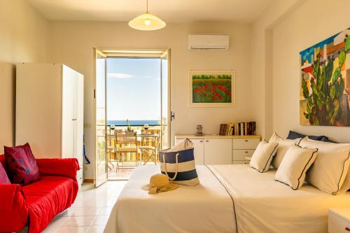 a living room with a bed and a red couch at La Casa Di Stefe in Giardini Naxos
