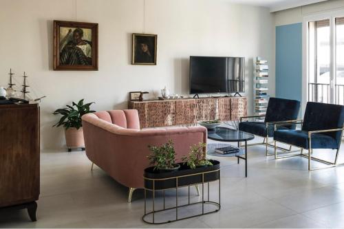 a living room with a couch and chairs and a tv at Elegant Apt In The Historical Center Of Avignon in Avignon