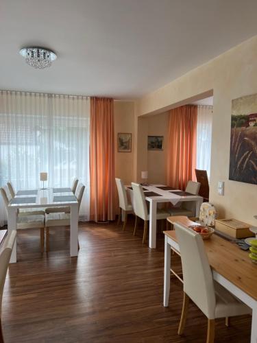 a dining room with white tables and white chairs at Gästehaus Elisabeth in Weisenheim am Sand