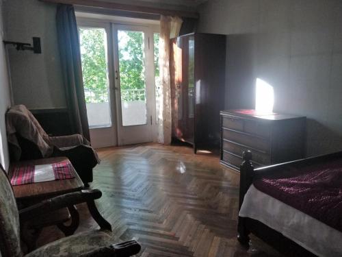 a room with a bed and a dresser and a chair at 5 minutes to subway in Tbilisi City