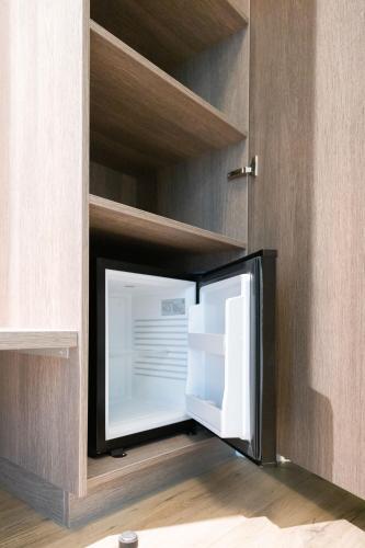 a small refrigerator in a cabinet with its door open at Hotel Erve Hulsbeek in Oldenzaal