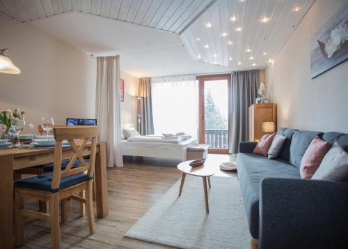 ein Wohnzimmer mit einem blauen Sofa und einem Tisch in der Unterkunft Bike & Ski kappe, am Bikepark, Skilift in Winterberg