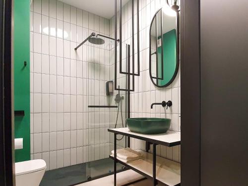 a bathroom with a green sink and a mirror at helloGdańsk in Gdańsk
