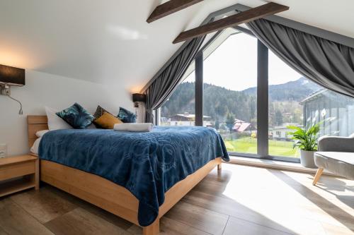 a bedroom with a bed and a large window at Apartamenty dla rodzin z sauną, bawialnią i widokiem na Skrzyczne - Dream Apart Marron in Szczyrk