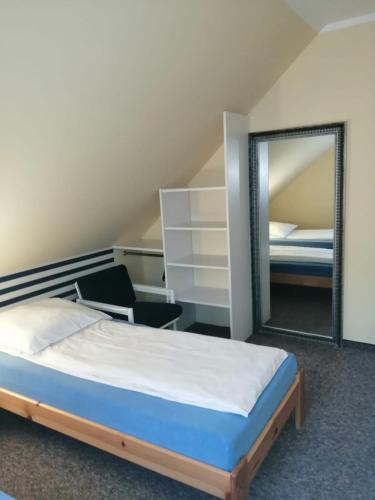 a bedroom with a bed and a mirror at Domek na Leśnej in Pogorzelica