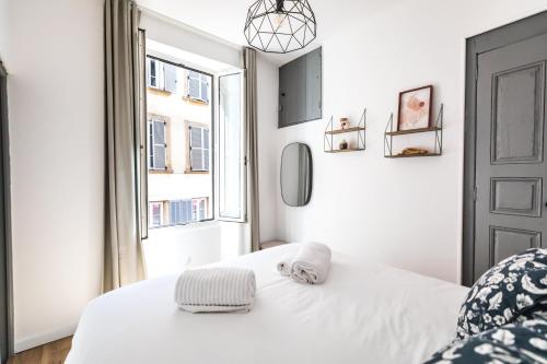 Habitación blanca con cama y ventana en 2 pièces neuf au pied des musées - wifi & parking gratuit, en Grasse