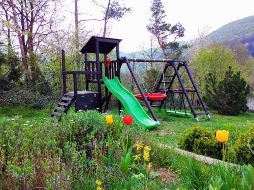 a playground with a slide in a garden with flowers at Helena Ferienwohnung in Hemfurth-Edersee
