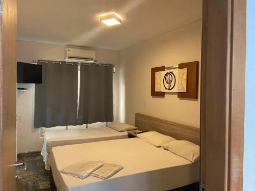 a room with two beds and a window at Hotel Imperador in Santos