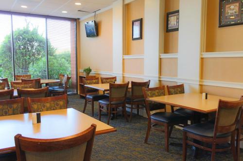 a restaurant with tables, chairs, and tables in it at Howard Johnson by Wyndham Atlanta Airport in Atlanta