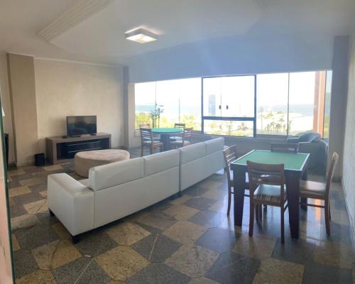 Hotel Imperador في سانتوس: غرفة معيشة مع أريكة بيضاء وطاولة