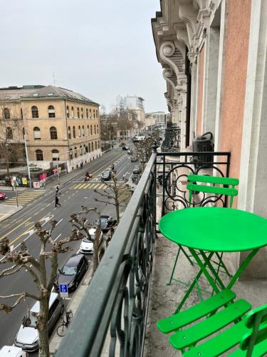 een groene tafel en stoelen op een balkon met een straat bij Luxury Apartment in Central Geneva in Genève