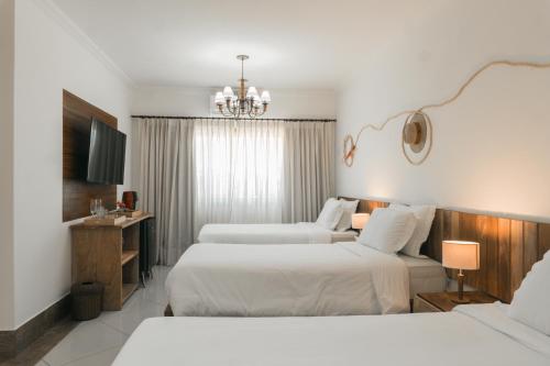 a hotel room with two beds and a chandelier at Santuário Hotel Fazenda in Santo André