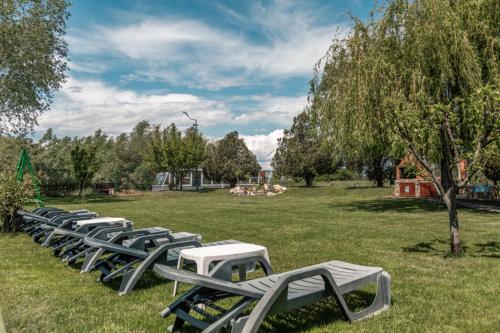 a row of chaise lounges in a park at Pensiunea Califar in Dunavăţu de Jos