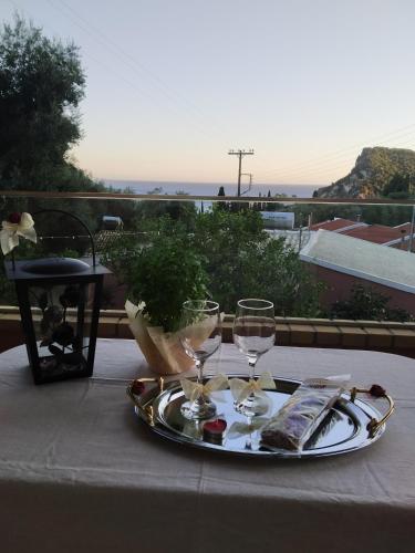 a table with a tray with wine glasses on it at Manganas Studios in Paleokastritsa