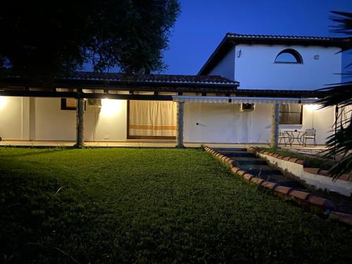 una casa con un patio verde por la noche en Villa sarda, en Assemini