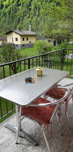 einen Tisch und Stühle auf dem Balkon in der Unterkunft Casa Betulla in Sonogno