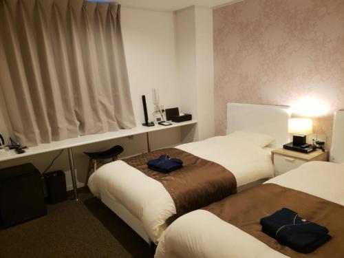a hotel room with two beds and a window at HOTEL CARNA A - Vacation STAY 53728v in Kumamoto