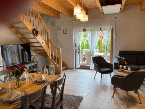 a living room with a wooden table and a dining room at Domek wakacyjny in Pogorzelica