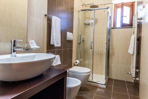 a bathroom with a sink and a toilet and a shower at Villa Ginevra Resort Agrituristico in Ficarra