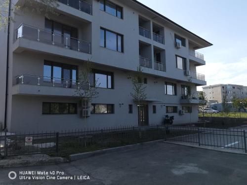 a white building with a fence in front of it at Studio Lorena in Mangalia