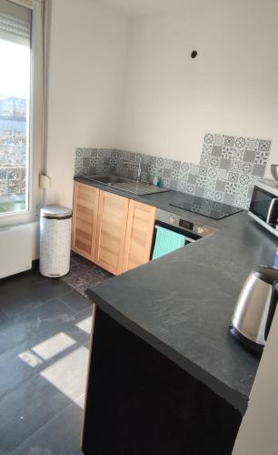 eine Küche mit einer schwarzen Arbeitsplatte in einem Zimmer in der Unterkunft F2 Paris Gare de Lyon en 20min in Villeneuve-Saint-Georges