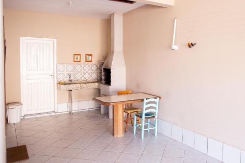 a kitchen with a table and chairs in a room at Recanto do Mar Pinheira in Palhoça