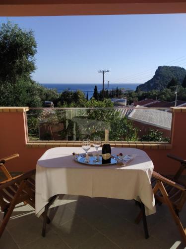 a table with a bottle of wine sitting on a balcony at Manganas Studios in Paleokastritsa