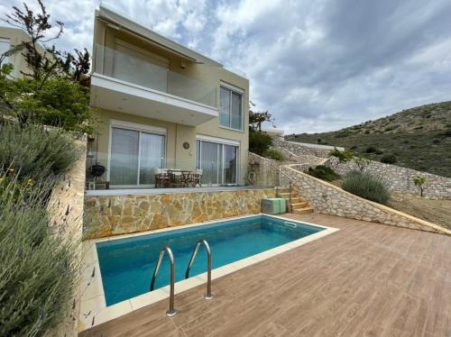 a villa with a swimming pool and a house at Villa Natalia in Tolo