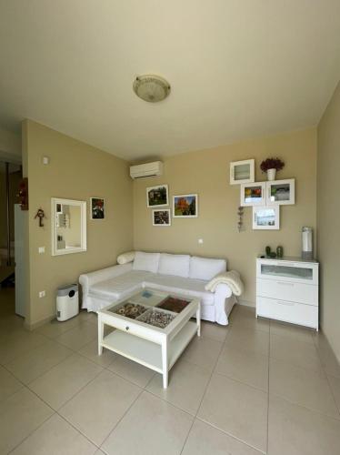a living room with a white couch and a table at Villa Natalia in Tolo