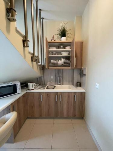 a small kitchen with a sink and a microwave at Villa Natalia in Tolo