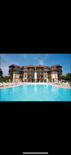 une grande piscine devant un immeuble dans l'établissement Le JLS Prestige 5 pers, à Deauville