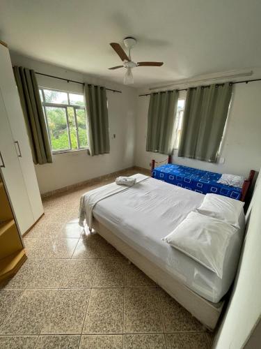 a bedroom with a bed with a ceiling fan at Pousada Regina in Cachoeiro de Itapemirim