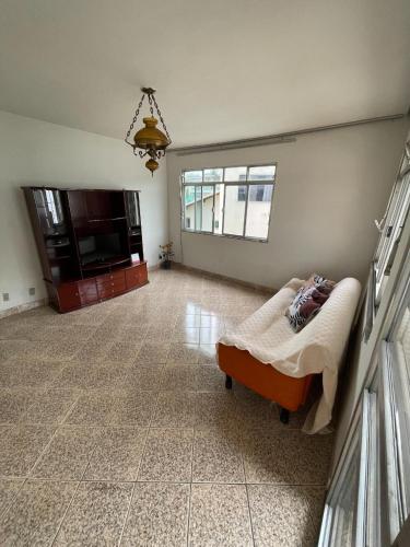 a living room with a bed and a television at Pousada Regina in Cachoeiro de Itapemirim